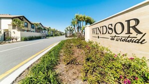 A sign for 'Windsor at Westside' with a road and residential buildings in the background.