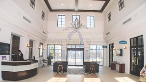 A spacious lobby with a reception desk, seating area, and large windows.