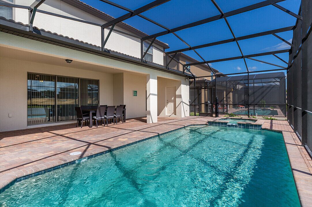 An outdoor swimming pool with a covered area and seating.