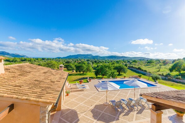 Zona de piscina en la azotea con vistas a un paisaje verde y montañas.