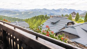 Vista de la montaña con un balcón de madera y edificios con techos inclinados.