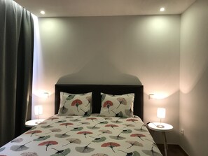 A hotel room with a bed, two bedside lamps, and a large window with curtains. - Povoa do Mar (Povoa De Varzim)