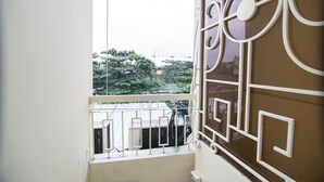 A balcony with a metal railing and a window with decorative white trim. - RedDoorz near Tan Son Nhat Airport 3 (Ho Chi Minh City)