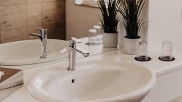 A bathroom with two sinks, a mirror, and a wooden wall.