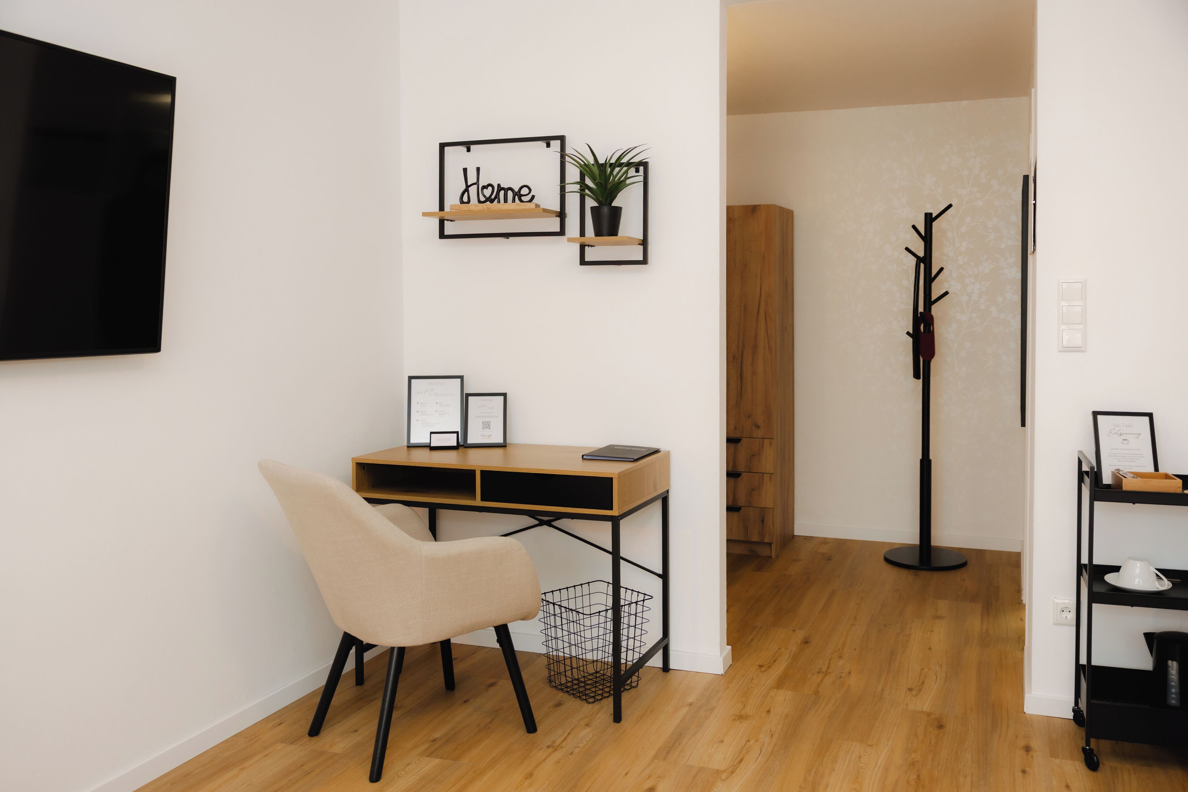 Un espacio de oficina moderno con un escritorio, una silla y estanterías en la pared.
