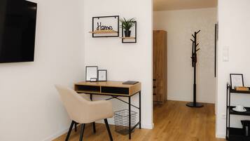 Un espacio de oficina moderno con un escritorio, una silla y estanterías en la pared.