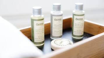 Three bottles of Touch Nature shampoo and bath products in a wooden tray.