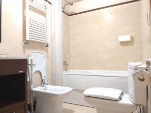 Kombination af bruser/badekar, hårtørrer, bidet, håndklæder