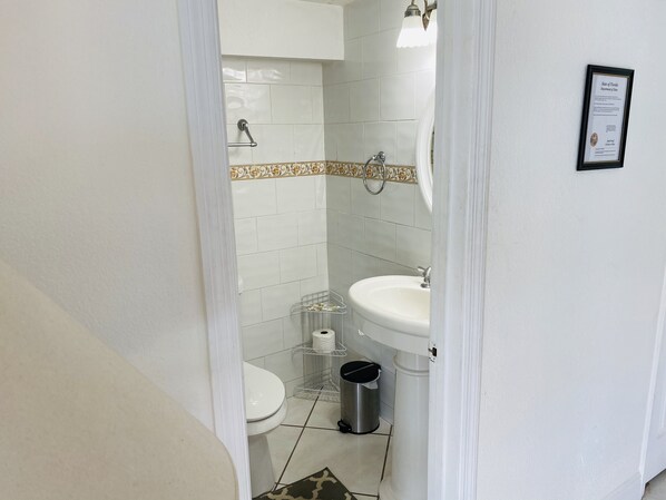 Une salle de bain avec des toilettes, un lavabo et une douche.
