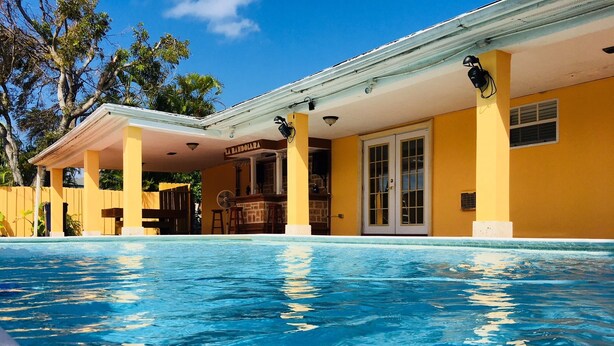 A swimming pool with a covered area and a bar.