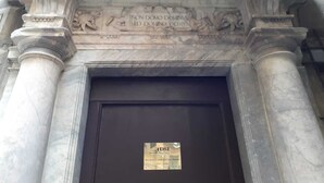 A marble entrance with inscriptions and a plaque.
