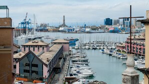 A marina with numerous boats docked, surrounded by buildings and industrial structures.