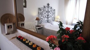 A hotel room with a bed, bedside table, lamp, and a decorative mirror. - Villa Tresino apartments "Velia" (Alani)