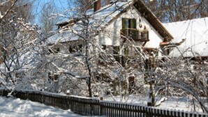 A snow-covered house with a wooden exterior, a balcony, and a visible chimney. - Martina's place (Rottenbuch)