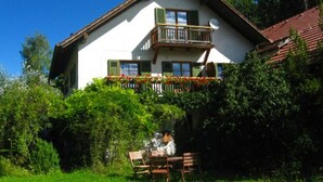 A two-story house with a balcony, surrounded by greenery. - Martina's place (Rottenbuch)