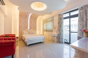 A modern bedroom with a bed, a desk, and a red chair. - Ali Ba Ba B&B II (Hualien City)