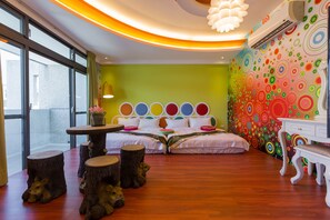 A room with two beds, a table, and a bench. There are decorative tree stumps and a colorful wall mural. - Ali Ba Ba B&B II (Hualien City)