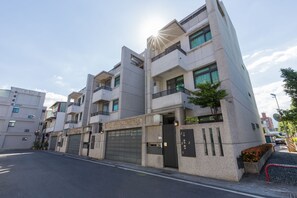 A modern multi-story residential building with a garage, balconies, and a clear sky. - Ali Ba Ba B&B II (Hualien City)