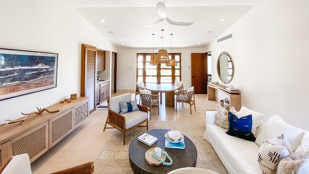 Un salón amplio con mesa de comedor, sofás y ventilador de techo.