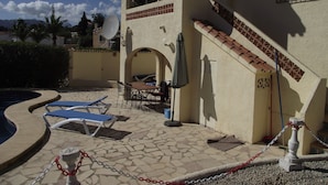 A poolside area with lounge chairs, a staircase, and a door leading to an upper level. - quietly situated villa at 900 m from the beach (Benissa)