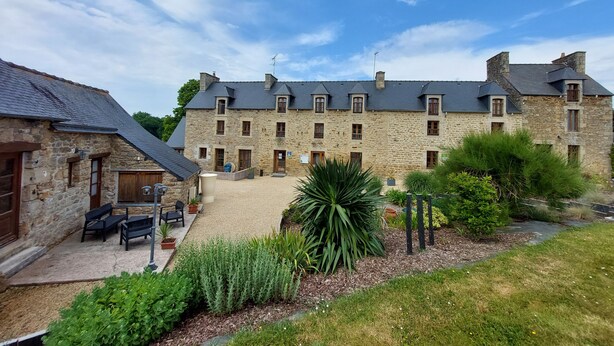 A stone building with multiple windows and a gravel courtyard. - Chambres d'Hôtes La Rompardais (Pleven)