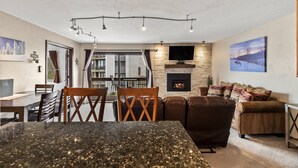 Una sala moderna con chimenea, comedor y un amplio ventanal.