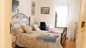 A bedroom with a bed, a desk, and a chair. - LA CASA DEI PARGOLI, apartment ideal for pleasant holidays in Matera (Matera)