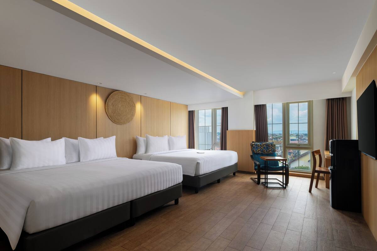 A hotel room with two beds, a TV, a balcony with a view, and a wooden wall.