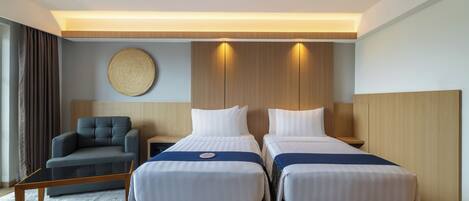 Ein Hotelzimmer mit zwei Betten, einer Couch, einer runden Wanddekoration und einer Holzbalkendecke.