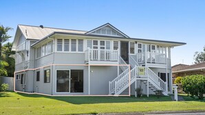 A two-story house with a covered porch, a staircase, and a garage. - 2-18 Mangrove Street (EVANS HEAD)