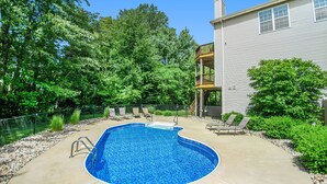 A backyard with a swimming pool, lounge chairs, and a wooden deck. - Private heated pool, Lake Michigan, tram to beach, fire pit, gas grill (South Haven)