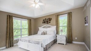 A bedroom with a white bed, two nightstands, a ceiling fan, and a window with curtains. - Private heated pool, Lake Michigan, tram to beach, fire pit, gas grill (South Haven)