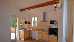 Una cocina con armarios de madera, lavavajillas, estufa y microondas.