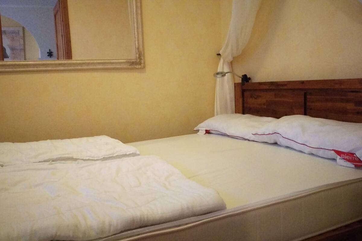 A single bed with white bedding and a wooden headboard.
