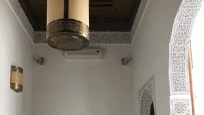 A dining area with a checkered floor, a wooden table, and four chairs. - Riad Jasmins & Spa (Fes)