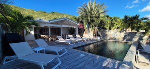 A poolside area with lounge chairs, a covered seating area, and a pool. - Waterfront villa 4 bedrooms, 3 bathrooms with pool, kayaks, high speed wifi (Cul-de-Sac)
