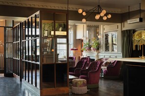 A room with a fireplace, purple upholstered chairs, and a large window. - Haddington House Hotel (Dublin)