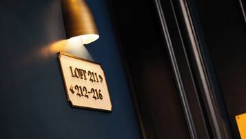 A wall-mounted light fixture with a sign indicating room number 211 and its range 212-216.