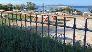 A coastal park with picnic tables and a view of the sea.