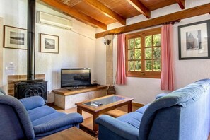 A cozy living room with a fireplace, a television, and comfortable seating.