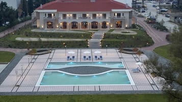 Una piscina al aire libre de temporada, sombrillas