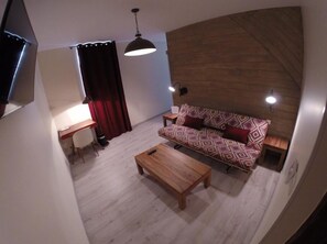 Suite, 1 grand lit et 1 canapé-lit | Salle de séjour | Télévision à écran plat