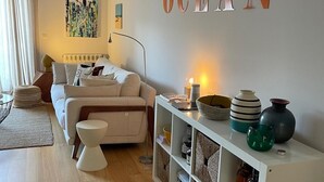 Un salon moderne avec un canapé, une table basse, une bibliothèque et le mot « OCÉAN » écrit en lettres volumineuses et fixé au mur.