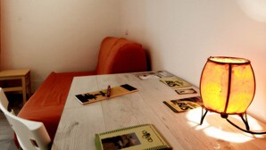 A small room with a wooden table, a red chair, and a floor lamp. - B&B La Rosa di Orvieto (Orvieto)