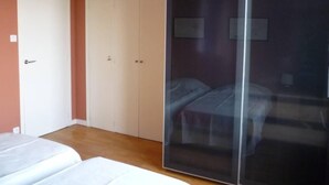 Une chambre à coucher avec un lit, une armoire et un miroir.