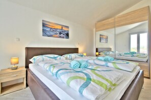 Relax in a spacious room with a large bed, nightstand, and mirror.