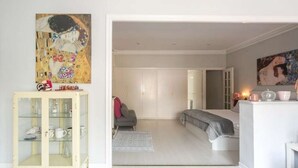 Un dormitorio moderno con una cama, un armario y un aparador de vidrio.