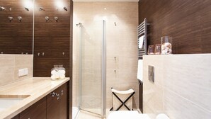 Een moderne badkamer met douche, toilet en wastafel.