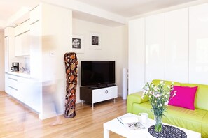 Un salon moderne comprenant un canapé, une table basse, un téléviseur et un objet décoratif en bois.