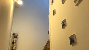 A staircase with wooden steps leading upwards, white walls, and several wall-mounted air conditioning units. - Apartment with cathedral view in the historical quarter  (Montpellier)